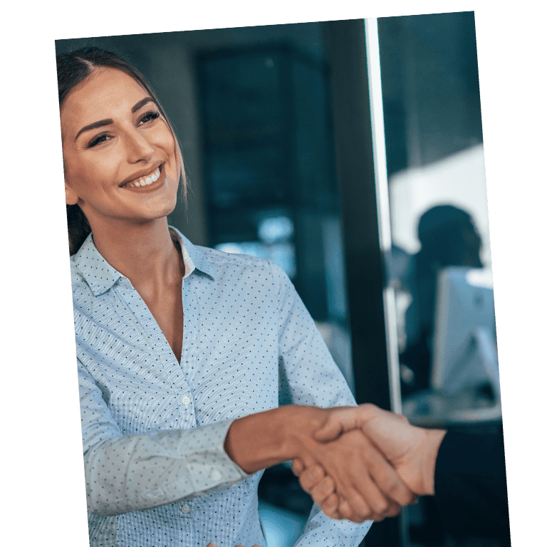 Two individuals wearing dress shirts shaking hands in a modern office setting.