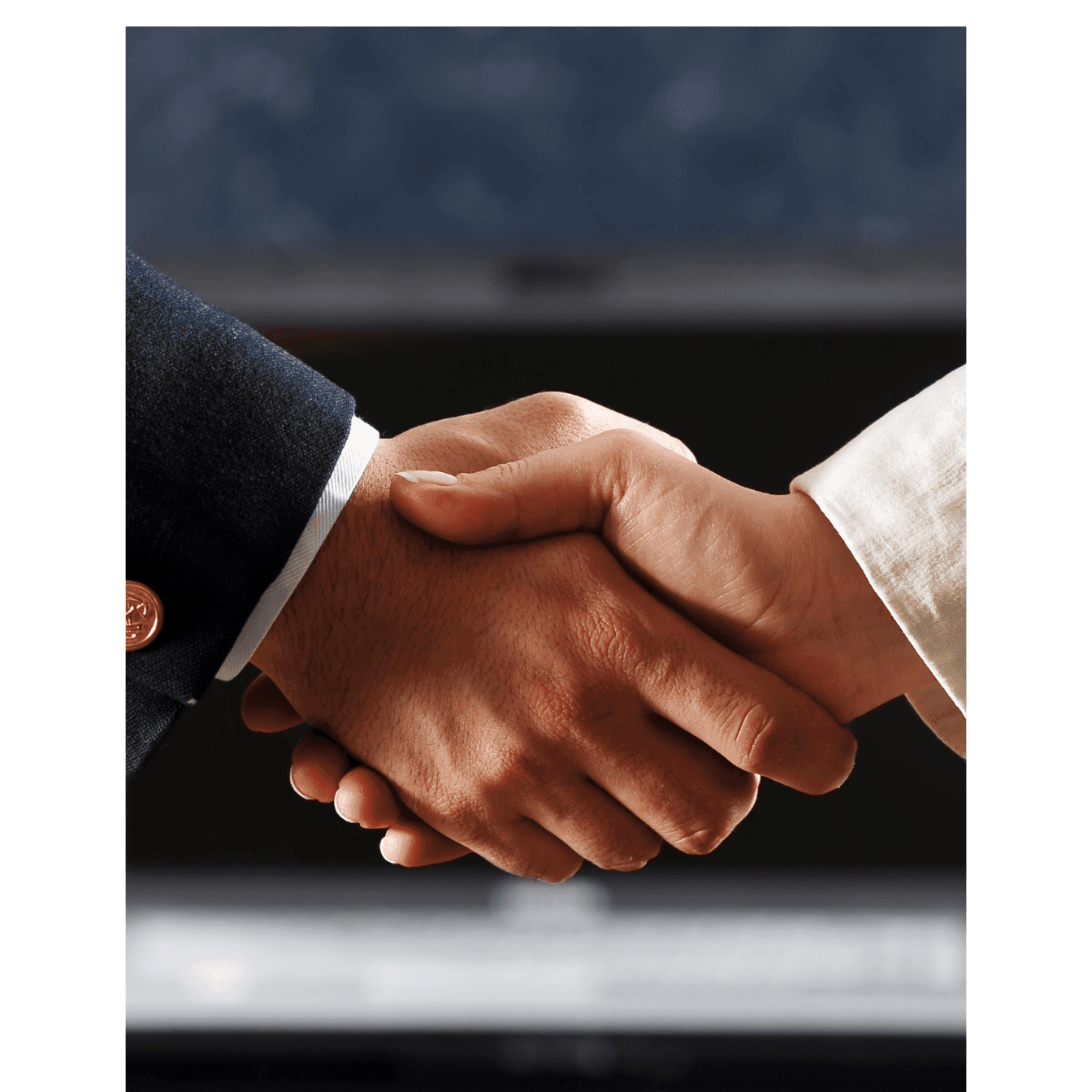 Close-up of a handshake between two people in formal attire.